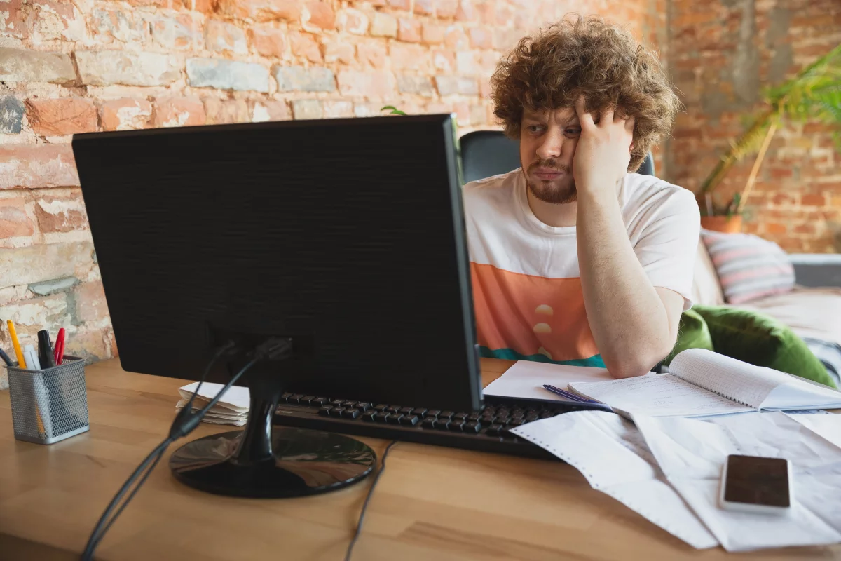 Muž pozerajúci sa na monitor sa chytá za hlavu pri učení zložitých nemeckých slov