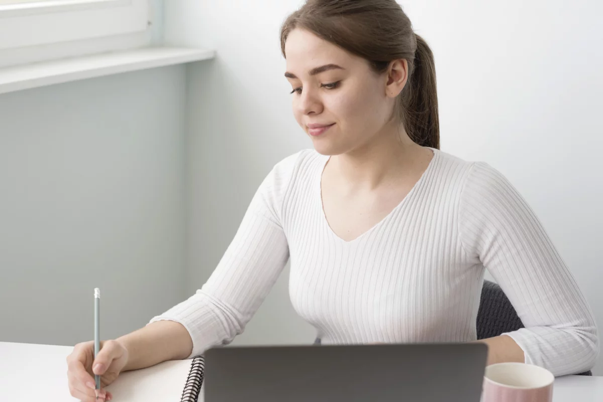 mladá žena si robí poznámky a vzdeláva sa na socialnej sieti linkedin 